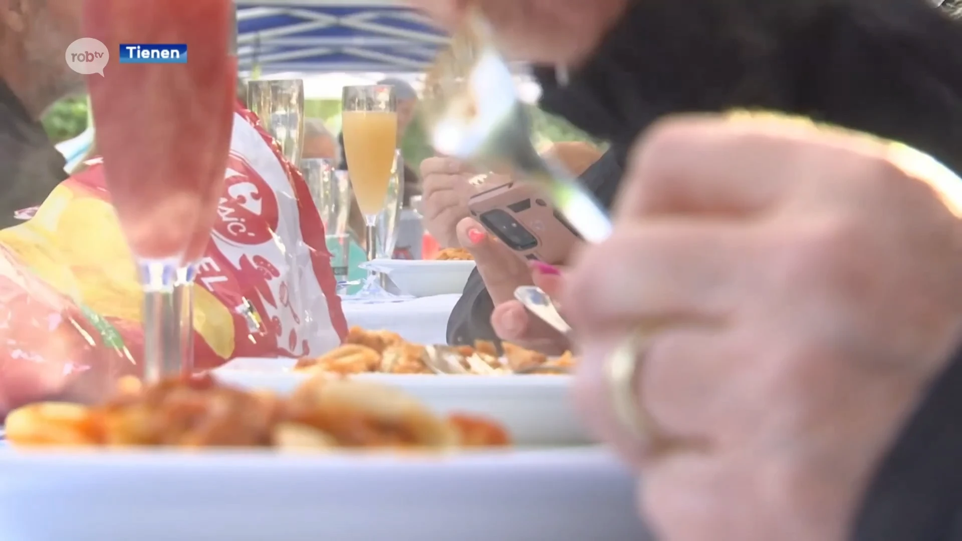 200 Tienenaars genieten van gratis maaltijd tijdens "De Langste Eettafel": "Het slechte weer kan ons niet tegenhouden"
