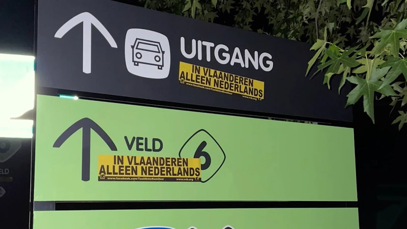 Franstalige tekst op tweetalige borden aan OHL overplakt met sticker: "In Vlaanderen alleen Nederlands"