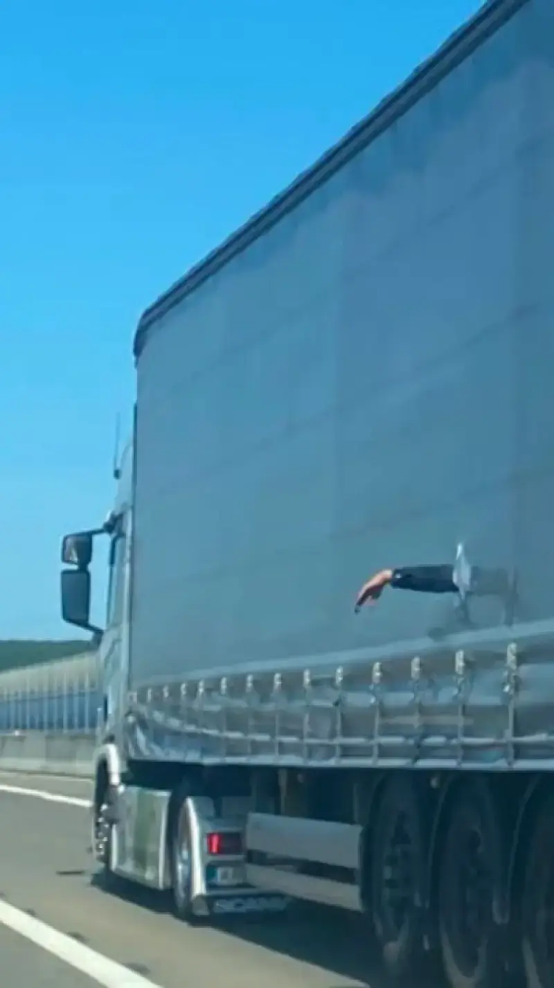 Man steekt zijn arm door het zeil van de vrachtwagen